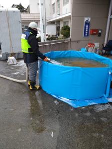 仮設トイレ用水槽への給水活動のようす