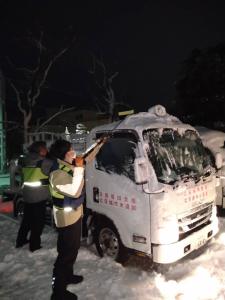 1月24日早朝、金沢市での給水車出動準備のようす (雪が積もった給水車と道路)